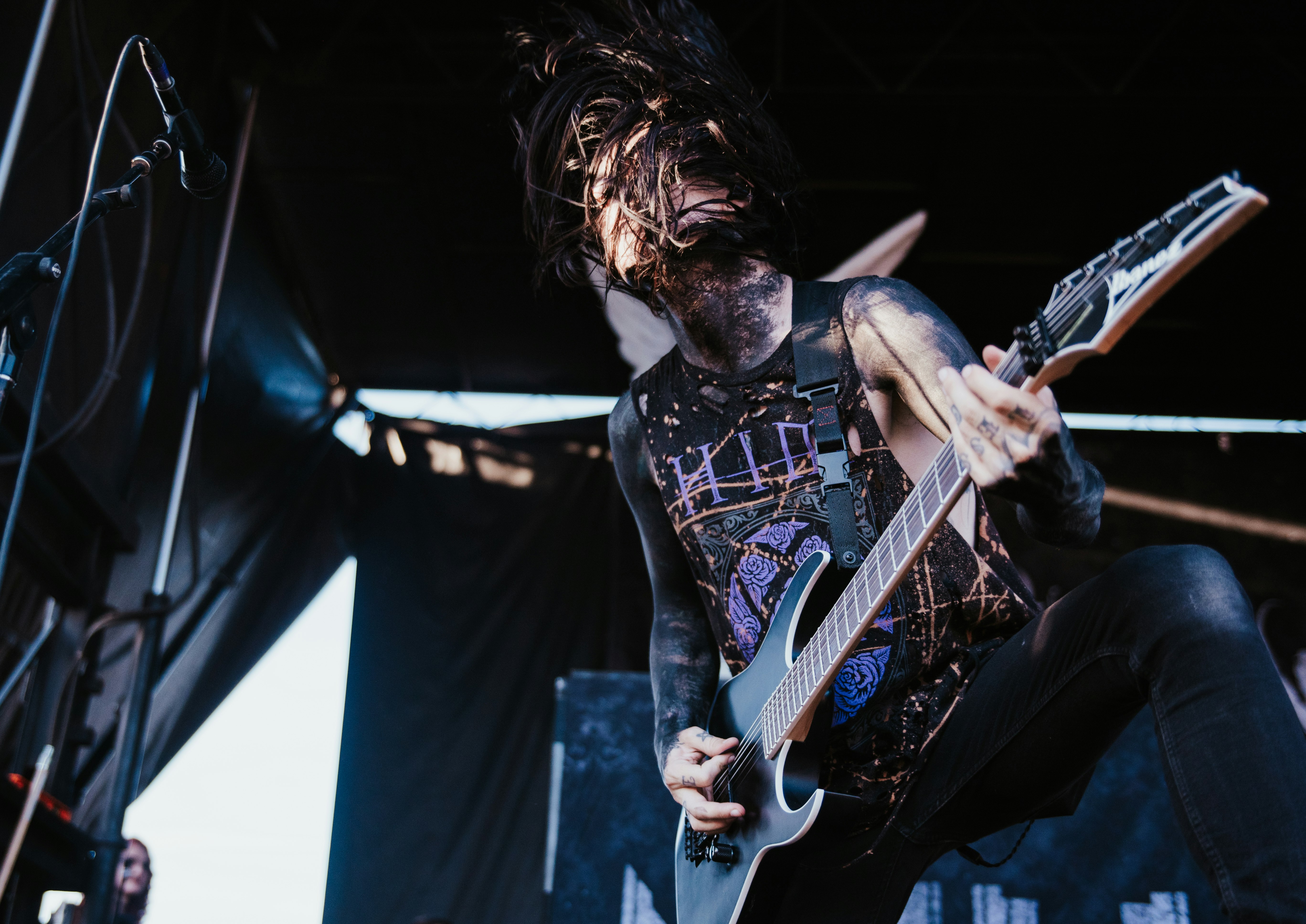 man in black and white crew neck t-shirt playing electric guitar